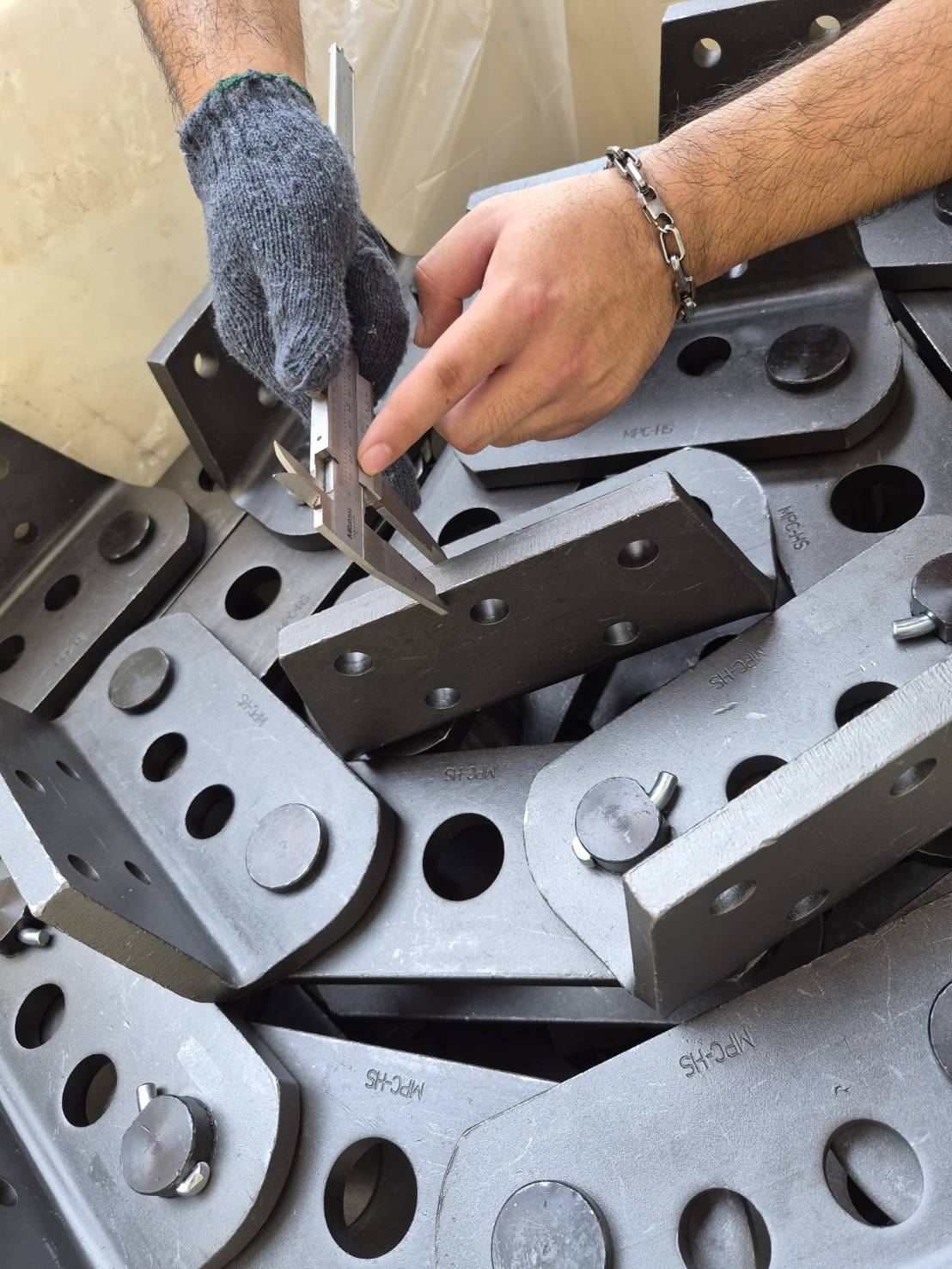 Precision caliper measurement of MPC-HS forged chain attachment plates during quality inspection